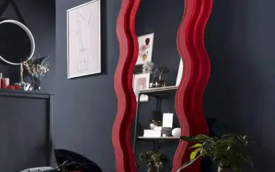 Ozdobne lustro z falowaną, czerwoną ramą. Dowiedz się, jak powiesić lustro z ramą, by stworzyć stylowe wnętrze.