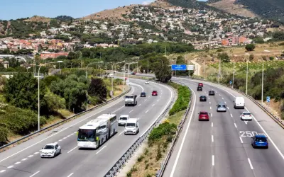 Voiture sur autoroute en Espagne, respectant la limitation vitesse espagne. Paysage vallonné avec des maisons en arrière-plan.