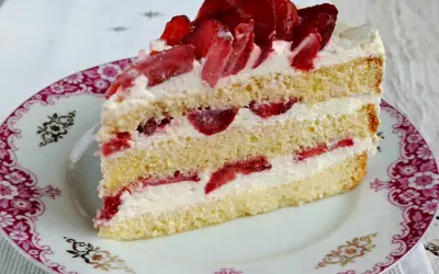 Pyszny biszkopt z serkiem mascarpone i bitą śmietaną, przełożony truskawkami. Idealny deser na każdą okazję.