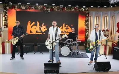 Zespół Kolaboranci, w tym Andrzej Kobra Kraiński, gra na scenie z świątecznymi dekoracjami.