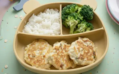 Deliciosas hamburguesas de pollo caseras para niños, acompañadas de arroz blanco y brócoli, servidas en un plato con forma de oso.