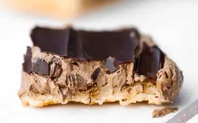 En närbild på en chokladbiskvi med krämig chokladfyllning och mörk chokladglasyr.