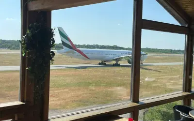 Ein Emirates-Flugzeug rollt auf dem Rollfeld. Perfekt für ein "Cafe to fly" mit Aussicht.