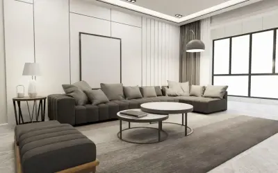 Nowoczesny salon z szarą sofą, dwoma stolikami kawowymi i dywanem. Wnętrze emanuje **quiet luxury**, gdzie każdy element jest dopracowany w subtelny sposób.
