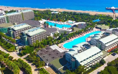 Luftaufnahme des von Resort Golden Coast, mit mehreren Gebäuden, Pools und dem Meer im Hintergrund.