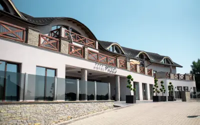Elegancki hotel Molo Resort z drewnianymi balustradami i kamienną podmurówką. Sprawdź molo resort ceny i zarezerwuj pobyt.