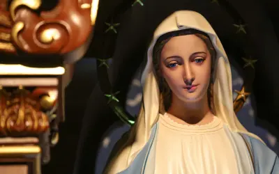 Figurka Matki Boskiej z błękitnymi oczami i aureolą gwiazd. Zastanawiamy się, ile lat żyła Maryja, gdy patrzymy na jej spokojną twarz.