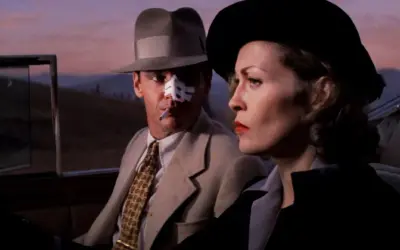 Jack Nicholson z plastrem na nosie i papierosem w ustach, obok Faye Dunaway w kapeluszu. Scena z jednego z filmów Romana Polańskiego.