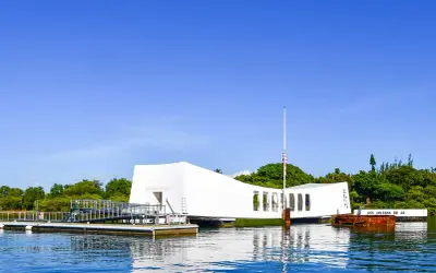 Pomnik USS Arizona w Pearl Harbor, biała konstrukcja nad wodą, upamiętnia tragiczne wydarzenia.