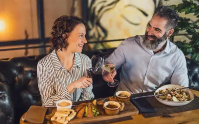 Para celebruje w najdroższej restauracji w Warszawie. Wznoszą toast winem, delektując się wykwintnym jedzeniem.