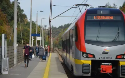 Pociąg Łódzkiej Kolei Aglomeracyjnej z numerem 11338 do Kutna stoi na peronie. Ludzie czekają na podróż.