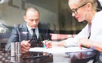 Radca prawny i prawnik analizują dokumenty przy biurku.