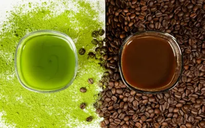 Zielony napój matcha obok ciemnej kawy, otoczone proszkiem matcha i ziarnami kawy. Wybór na poranek: matcha zamiast kawy?