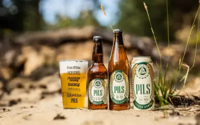 Szklanka i butelki piwa lager PILS Trzech Kumpli, a także puszka. Idealne piwo lager przykłady na letni relaks.