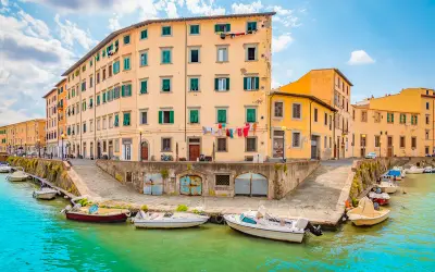 Canali di Livorno, un'idea per cosa vedere a Livorno in un giorno. Case colorate e barche sull'acqua turchese.