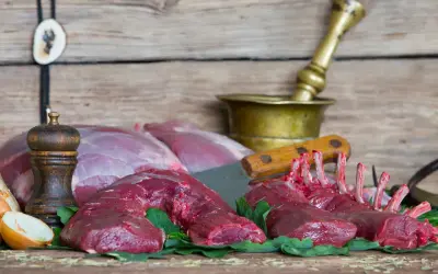 Surowe mięso sarny, żeberka i kawałki na desce. Zastanawiasz się, ile kosztuje sarna?