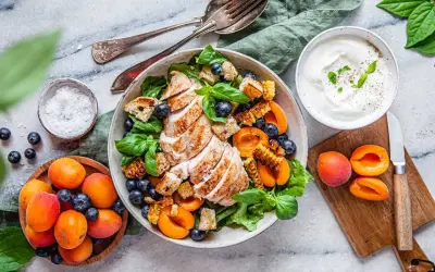 En läcker grillad kyckling sallad med blåbär, aprikoser och krutonger. Serveras med en krämig yoghurtdressing.