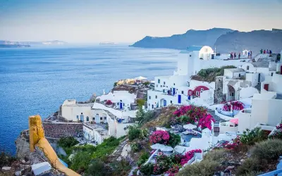 Malownicze białe domy na Santorini, kwitnące bugenwille i błękitne morze. Czy do Grecji potrzebny jest paszport? Tak, jeśli nie jesteś obywatelem UE.