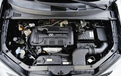 Silnik DOHC 16V w Hyundai Tucson 2007. Widoczny układ dolotowy i elementy osprzętu.