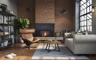 Przytulny, **soft loft** z ceglaną ścianą, palącym się kominkiem, wygodną kanapą i fotelem.