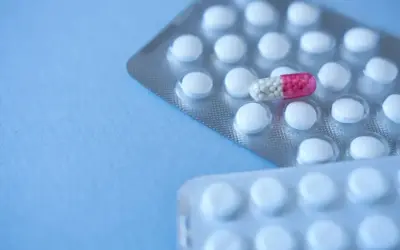 Blister opakowań tabletek, jedna kapsułka z różowym czubkiem. Clonazepam na co? Na niepokój, bezsenność.
