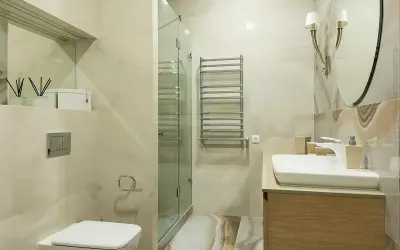 Baño moderno con ducha de cristal, lavabo y WC. Ideal para instalar extractor baño y mantener el ambiente fresco.
