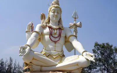 Stor staty av Shiva, en viktig gudom inom hinduismen, sitter i meditation med en orm runt halsen och en treudd i handen.