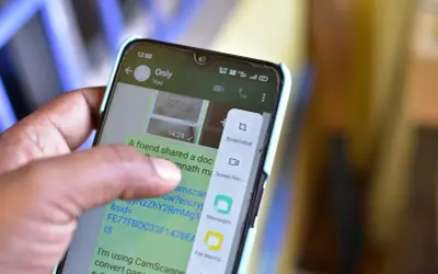 Palec dotyka ekranu telefonu, wybierając opcję "Screenshot", aby pokazać, jak zrobić screena.