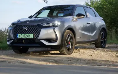 Srebrny DS3 Crossback na drodze gruntowej, z zieloną tablicą rejestracyjną.