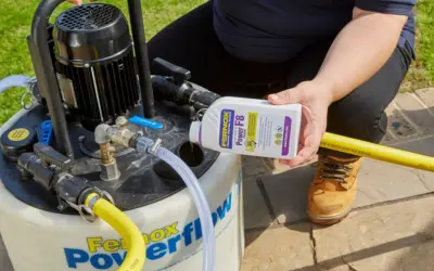 Osoba dodaje środek do czyszczenia instalacji co do urządzenia Fernox Powerflow.