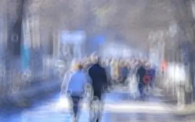 Rozmyty tłum ludzi na ulicy, jakby patrzyli przez szkło z podwójnym widzeniem z daleka.