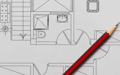 Un crayon rouge et noir sur un plan de maison, idéal pour faire un plan de maison gratuit et visualiser votre projet.