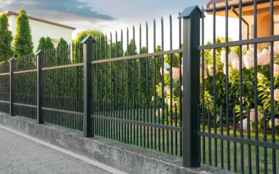 Czarnym metalowym ogrodzeniem z podmurówką. Zastanawiasz się, czym pomalować podmurówkę ogrodzenia?