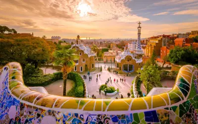 Park Güell w Barcelonie, jedno z najlepszych miast do odwiedzenia w Hiszpanii, zachwyca mozaikową ławką i bajkowymi budynkami o zachodzie słońca.