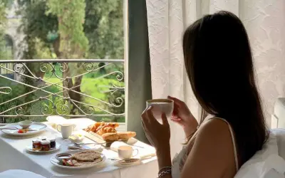 Colazione in camera a Roma: croissant, pancake e caffè con vista sul verde. Un'ottima opzione per sapere dove dormire a Roma.