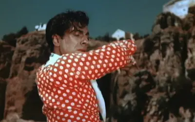 Un hombre con camisa de lunares rojos y blancos, bailando con pasión. Su gesto evoca la fuerza de la contrahecha.