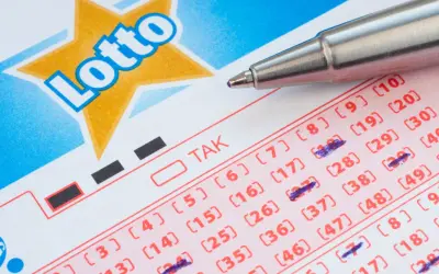 Kupon Lotto z zaznaczonymi liczbami, gotowy do gry w multi systemy na 3 liczby. Długopis czeka na kolejne wybory.