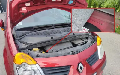 Czerwony Renault z otwartą maską. W powiększeniu widać numer VIN wybity na karoserii pod wygłuszeniem.