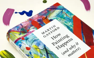 A book titled "How Painting Happens" by Martin Gayford, featuring a vibrant, abstract cover that evokes the spirit of figurative painting. Splatters of paint surround it.