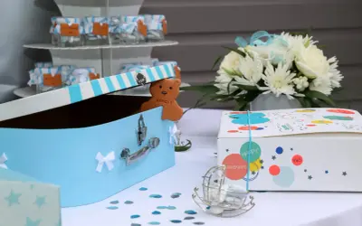 Une boîte à trésors bleue pour un baptême, avec un ours en biscuit "Merci !" et des petits pots de dragées. Une idée de gazette baptême à télécharger.