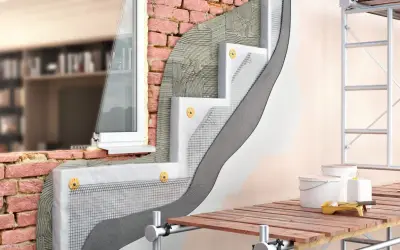 Dettaglio costruttivo di un cappotto termico esterno con isolante, rete e intonaco. Il miglior intonaco per cappotto esterno garantisce protezione e finitura.