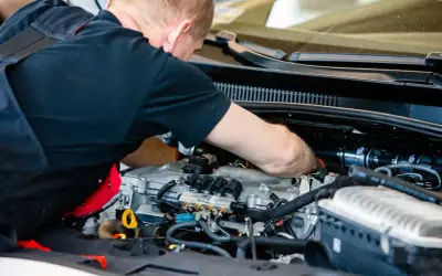 Mechanik pracuje przy silniku z instalacją gazową. Sprawdza podzespoły, by zapewnić optymalną cng cenę za litr.