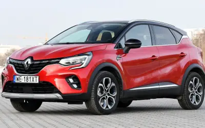 Czerwony Renault Captur na tle miejskiego krajobrazu. Zastanawiasz się, renault captur jaki silnik wybrać?