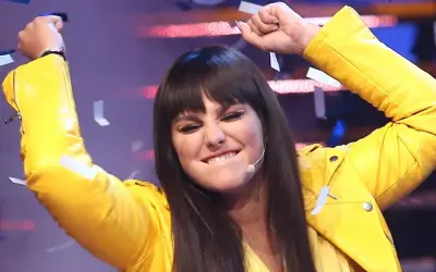 Ewa Farna w żółtej ramonesce, z uniesionymi rękami i konfetti, śpiewa "Bez łez".