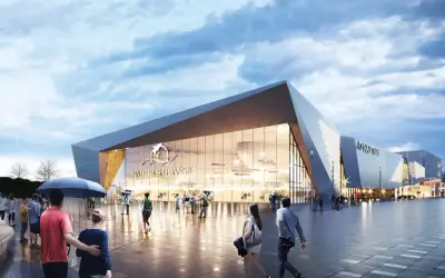 Nowoczesny budynek oceanarium Gdańsk z napisem "Nautilus Gdańsk" i logo delfina. Ludzie spacerują po placu przed budynkiem.