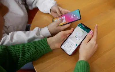Dwie osoby korzystają z telefonów. Jedna z nich ma na ekranie mapę i klawiaturę, jak w systemie android 10.