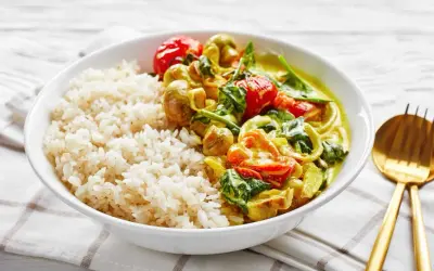 Pyszne dania na ciepło bez mięsa: ryż z aromatycznym curry warzywnym, pomidorkami i szpinakiem.