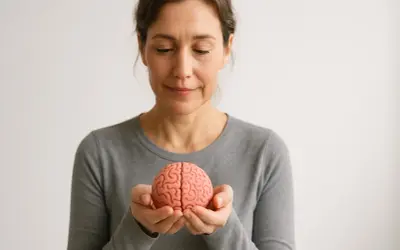Donna con un modello di cervello tra le mani, simbolo della plasticità neuronale e del potenziale di apprendimento.