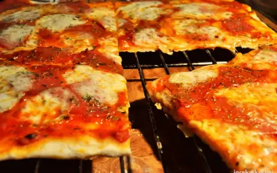 Pyszna pizza na cienkim cieście, z ciągnącym się serem i aromatycznym sosem pomidorowym, prosto z pieca.
