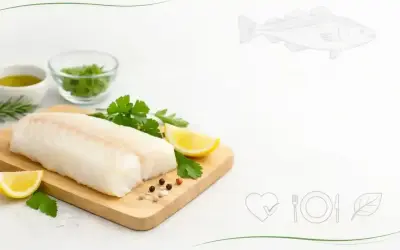 Świeży filet z dorsza na desce z cytryną i ziołami. Niska zawartość dorsz kcal czyni go idealnym wyborem dla dbających o linię.